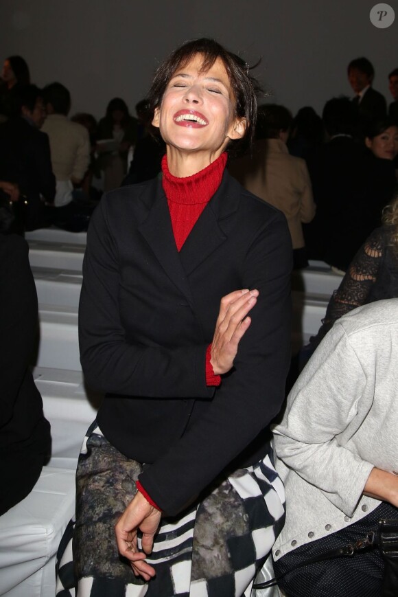 Sophie Marceau, en plein éclat de rire au premier rang du défilé Agnès B. printemps-été 2013 au musée du Jeu de Paume. Paris, le 2 octobre 2013.