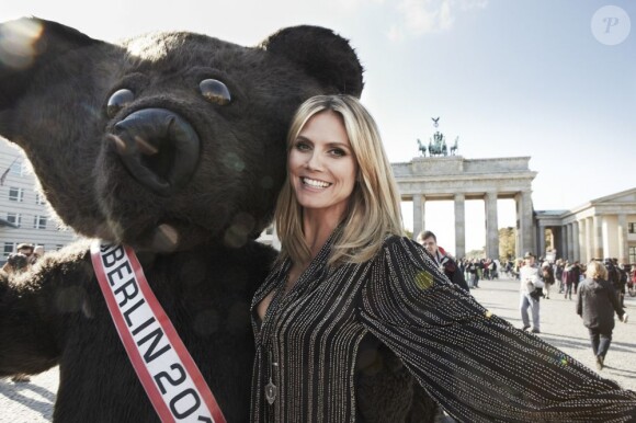 Heidi Klum, ambassadrice d'Astor, pose devant la porte de Brandebourg à Berlin avec un ours, symbole de la capitale allemande. Le 16 octobre 2012.