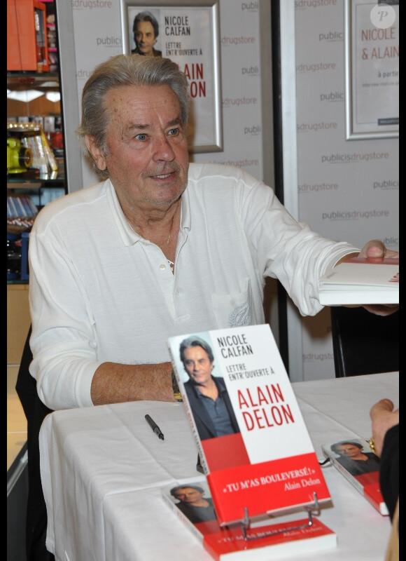 Alain Delon et Nicole Calfan dédicacent le livre de cette dernière, Lettre entr'ouverte à Alain Delon, le mardi 30 octobre 2012 au Drugstore Publicis à Paris.