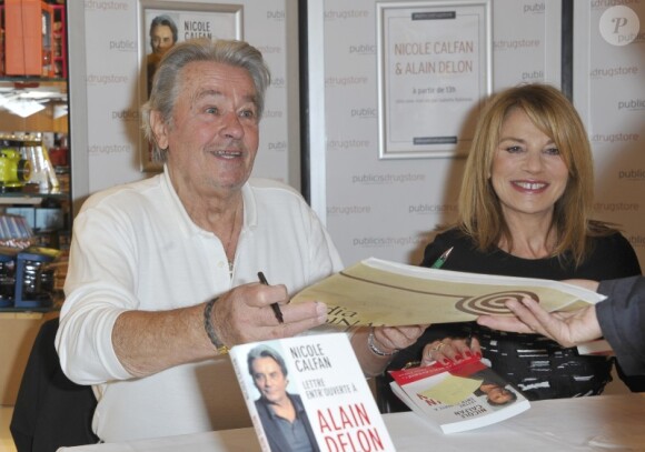 Alain Delon et Nicole Calfan dédicacent le livre de cette dernière, Lettre entr'ouverte à Alain Delon, le mardi 30 octobre 2012 au Drugstore Publicis à Paris.