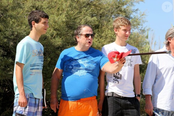Paul-Loup Sulitzer entouré de ses fils James et Edouard au Club 55, près de Saint-Tropez, le 16 juillet 2012.