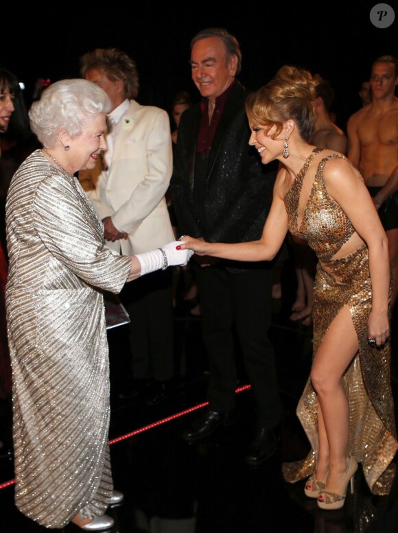 La reine Elizabeth II salue Kylie Minogue, ravie et très fendue ! 100e gala du Royal Variety au Royal Albert Hall, à Londres, le 19 novembre 2012, en présence de la reine Elizabeth II et du prince Philip.