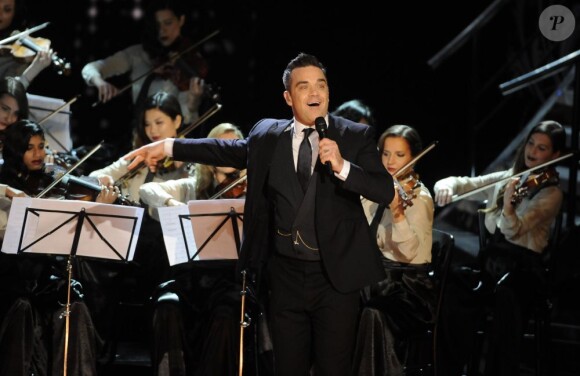 Robbie Williams sur scène pour le 100e gala du Royal Variety au Royal Albert Hall, à Londres, le 19 novembre 2012, en présence de la reine Elizabeth II et du prince Philip.