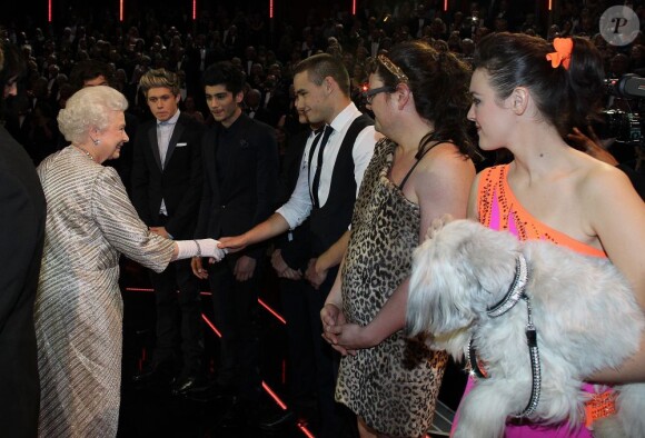 Elizabeth II salue les One Direction au 100e gala du Royal Variety au Royal Albert Hall, à Londres, le 19 novembre 2012, en présence de la reine Elizabeth II et du prince Philip.
