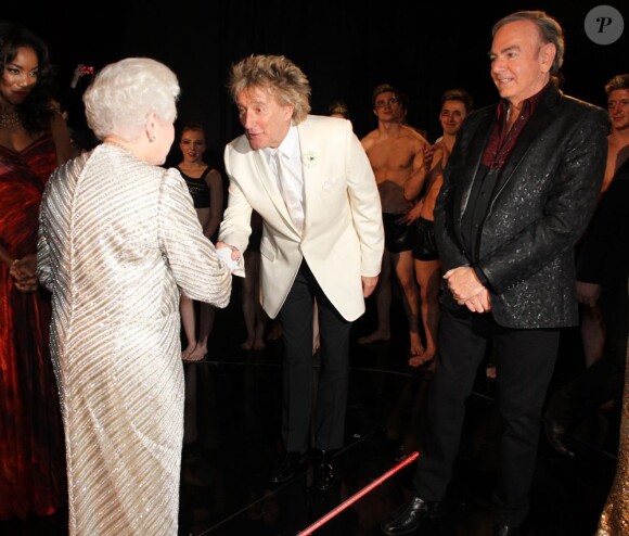 Rod Stewart salue avec effusion la reine Elizabeth II. Soirée du 100e gala du Royal Variety au Royal Albert Hall, à Londres, le 19 novembre 2012, en présence de la reine Elizabeth II et du prince Philip.