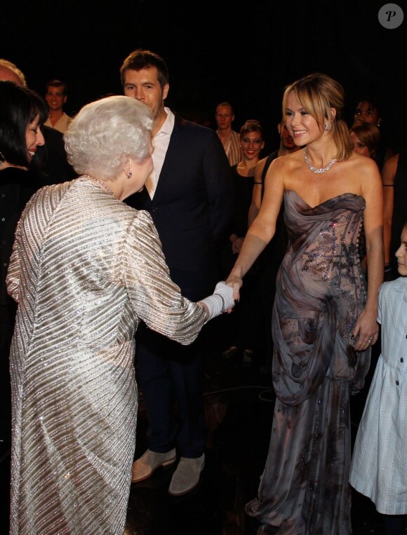 Amanda Holden saluée par la reine Elizabeth II. Soirée du 100e gala du Royal Variety au Royal Albert Hall, à Londres, le 19 novembre 2012, en présence de la reine Elizabeth II et du prince Philip.