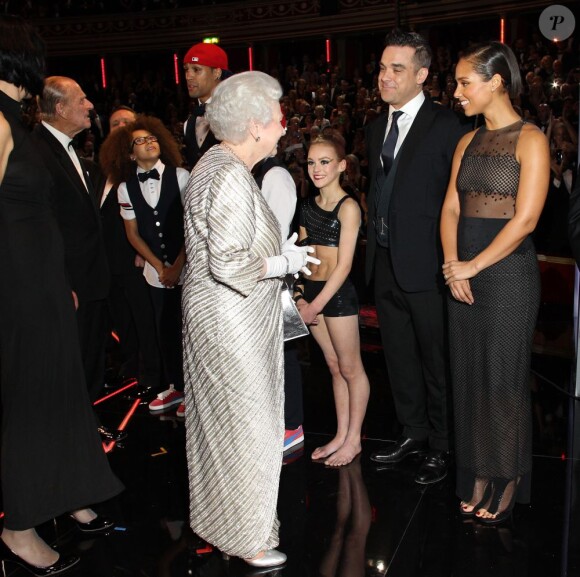 Elizabeth II saluant Robbie Williams et Alicia Keys lors de la soirée du 100e gala du Royal Variety au Royal Albert Hall, à Londres, le 19 novembre 2012.