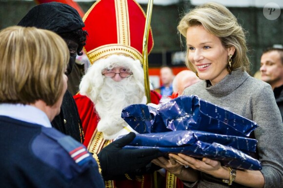La princesse Mathilde de Belgique les bras chargés de cadeaux à Peutie le 1er décembre 2012 pour la 8e Journée Nationale Info-Familles (JNIF) consacrée aux proches des militaires belges oeuvrant pour la paix à l'étranger.
