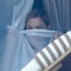 Madonna se cache derrière les rideaux de sa chambre d'hôtel à Rio de Janeiro, le 1er décembre 2012.