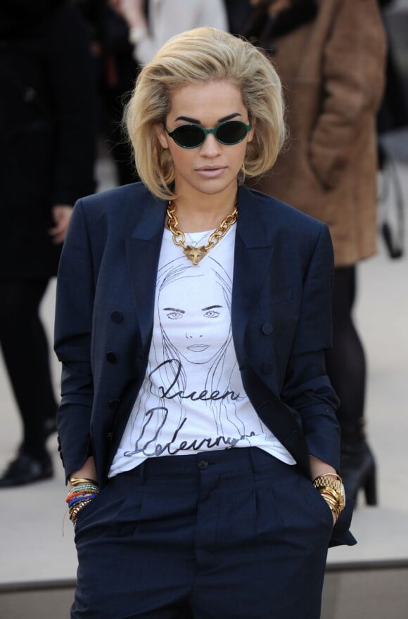 La chanteuse Rita Ora arrive à Hyde Park pour assister au défilé Burberry Prorsum automne-hiver 2013, habillée d'un T-shirt à l'effigie de sa meilleure amie Cara Delevingne. Londres, le 18 février 2013.