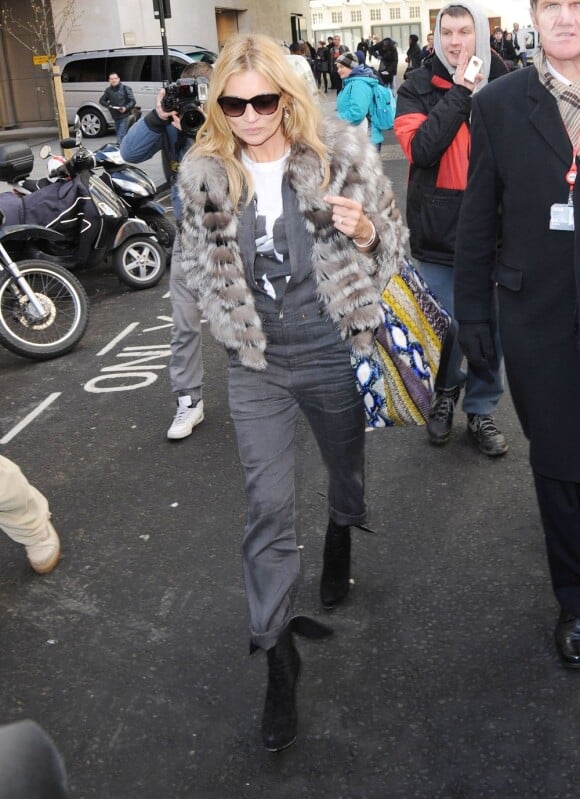 Kate Moss quitte les studios de la radio BBC Radio 1, habillée d'une veste en fourrure, d'une combinaison grise et de bottines Azzedine Alaïa. Londres, le 14 mars 2013.