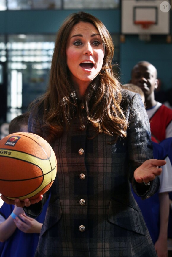 Kate Middleton tente un panier au centre de loisirs Donald Dewar de Glasgow le 4 avril 2013, au cours de sa visite avec le prince William en Ecosse, où ils sont connus comme le comte et la comtesse de Strathearn.