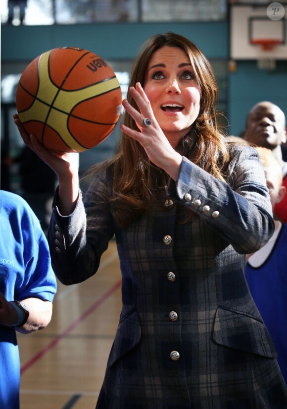 Kate Middleton tente un panier au centre de loisirs Donald Dewar de Glasgow le 4 avril 2013, au cours de sa visite avec le prince William en Ecosse, où ils sont connus comme le comte et la comtesse de Strathearn.