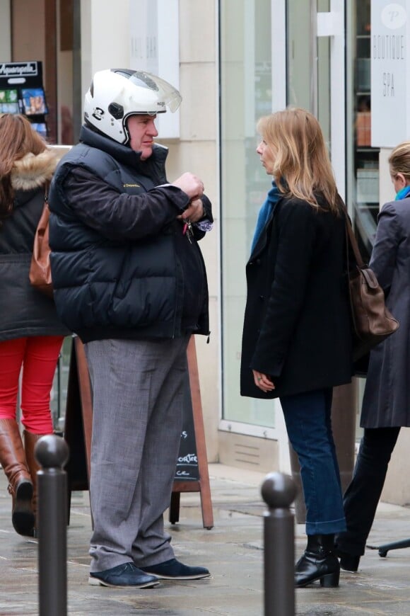 Gérard Depardieu et une passante dans les rues de Paris le 11 avril 2013.