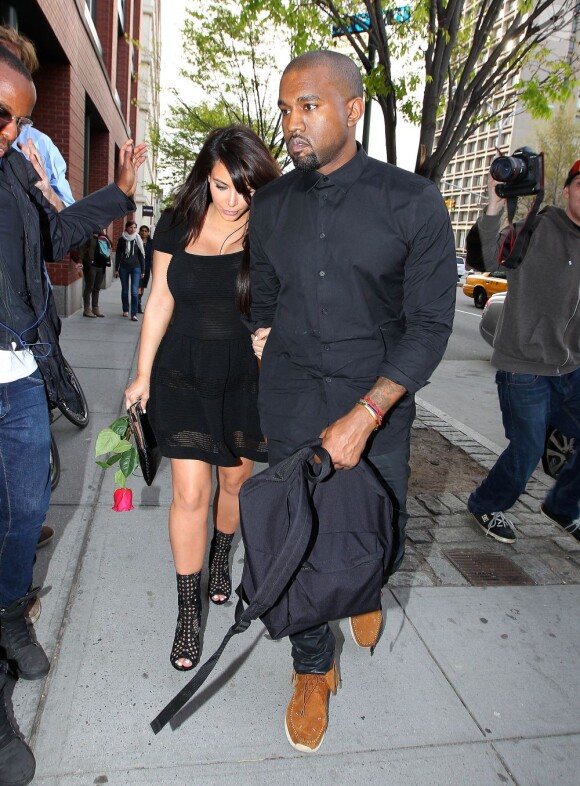 Kim Kardashian et Kanye West, tous de noir vêtus, sont surpris main dans la main à New York. Le 24 avril 2013.