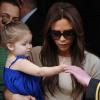 Victoria Beckham habillée d'une jupe et d'une pochette Victoria Beckham et de sandales Chloé avec sa fille Harper à Londres. Le 24 avril 2013.