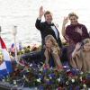 Le roi Willem-Alexander des Pays-Bas, la reine Maxima et leurs filles Catharina-Amalia et Alexia saluent le public lors de la parade aquatique précédant le banquet final de l'intronisation du fils de la princesse Beatrix, le 30 avril 2013 à Amsterdam.