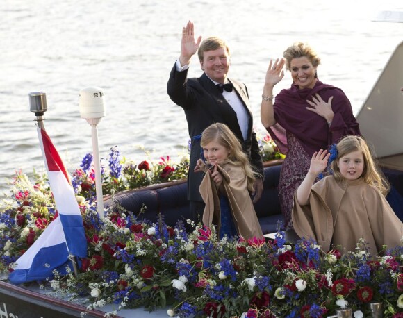 Le roi Willem-Alexander des Pays-Bas, la reine Maxima et leurs filles Catharina-Amalia et Alexia saluent le public lors de la parade aquatique précédant le banquet final de l'intronisation du fils de la princesse Beatrix, le 30 avril 2013 à Amsterdam.