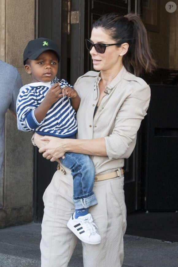 La belle Sandra Bullock quitte son hôtel avec son fils Louis, à Berlin en Allemagne, le 19 juin 2013.