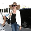 Anne Hathaway à l'aéroport de Los Angeles, porte avec sa veste blanche un jean craqué aux genoux Genetic Denim et un sac Stella McCartney. Le 22 mars 2013.