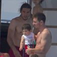 Les joueurs du FC Barcelone Lionel Messi, Cesc Fabregas, et José Manuel Pinto passent des vacances à Ibiza avec leurs familles et le pilote moto Sete Gibernau le 9 juillet 2013.