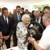 La reine Elizabeth II visitant le 11 juillet 2013 les installations du Coronation Festival organisé à Buckingham Palace à l'occasion des 60 ans de son couronnement par la Royal Warrants Holders Association.