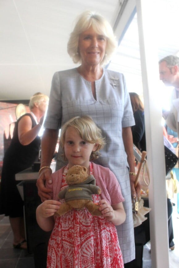 Camilla Parker Bowles posant avec la jeune Jessica Fitch et son ourson Bertie,  le 11 juillet 2013 au premier jour du Coronation Festival organisé à Buckingham Palace par la Royal Warrants Holders Association à l'occasion des 60 ans du couronnement d'Elizabeth II.