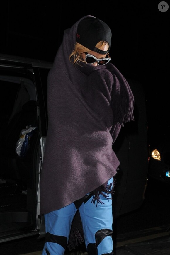 Rihanna rentre à son hôtel et se cache des photographes sous une couverture à Londres le 16 juillet 2013.