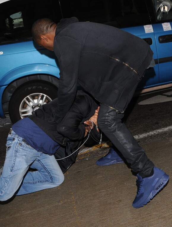 Kanye West se bagarre avec un photographe à son arrivée à l'aéroport LAX de Los Angeles, le 19 juillet 2013.