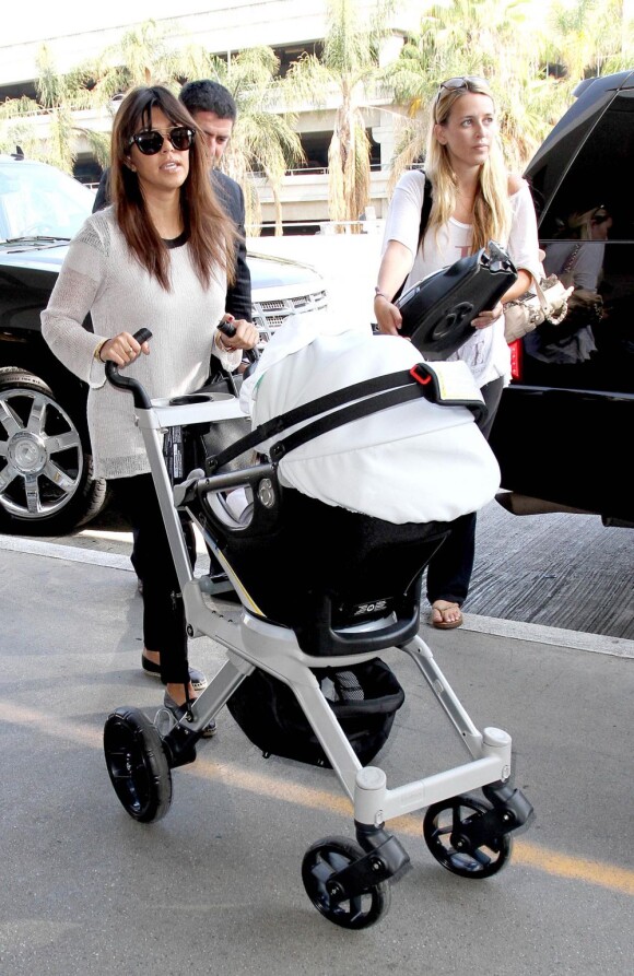 Kourtney Kardashian en compagnie de ses enfants Mason et Penelope à l'aéroport LAX de Los Angeles, le 19 juillet 2013.