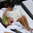 Kourtney Kardashian se relaxe avec son fiancé Scott Disick et leurs enfants Mason et Penelope au bord d'une piscine à Miami, le 20 juillet 2013. L'aînée du clan Kardashian donne le sein à la petite Penelope.
