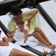 Kourtney Kardashian se relaxe avec son fiancé Scott Disick et leurs enfants Mason et Penelope au bord d'une piscine à Miami, le 20 juillet 2013. L'aînée du clan Kardashian donne le sein à la petite Penelope.