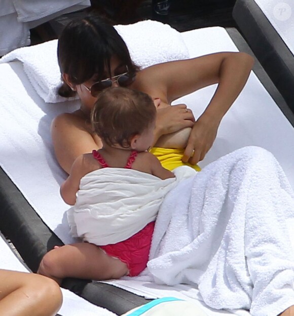 Kourtney Kardashian se relaxe avec son fiancé Scott Disick et leurs enfants Mason et Penelope au bord d'une piscine à Miami, le 20 juillet 2013. L'aînée du clan Kardashian a donné le sein à la petite Penelope.