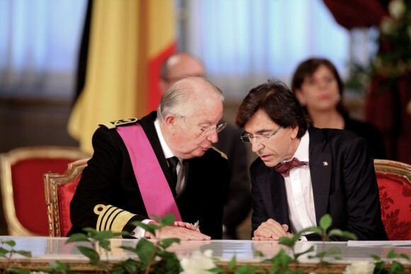 Albert II de Belgique papote avec le Premier ministre ELio Di Rupo au moment de signer l'acte d'abdication à Bruxelles, le 21 juillet 2013.