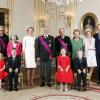 Portrait officiel (de gauche à droite) : Le prince Laurent et son épouse, la princesse Claire, la reine Mathilde et le roi Philippe, le roi Albert II et la reine Paola, la princesse Astrid et son époux, le prince Lorenz. Au premier rang, les enfants de Mathilde et Philippe : Éléonore, Gabriel, Élisabeth et Emmanuel. Dans les salons du palais royal à Bruxelles, le 21 juillet 2013.