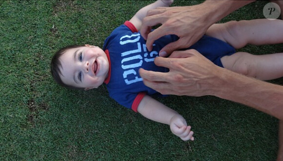 Le petit Milan a le droit à une séance de chatouilles de la part de son papa durant ses vacances à Hawaï en juillet 2013