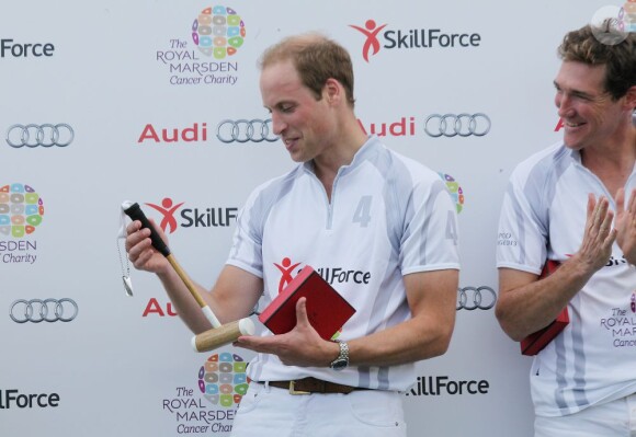 Le prince William découvre le mini maillet qui est offert à son fils, après le match caritatif The Audi Polo Challenge au parc Coworth à Berkshire, le 3 août 2013.