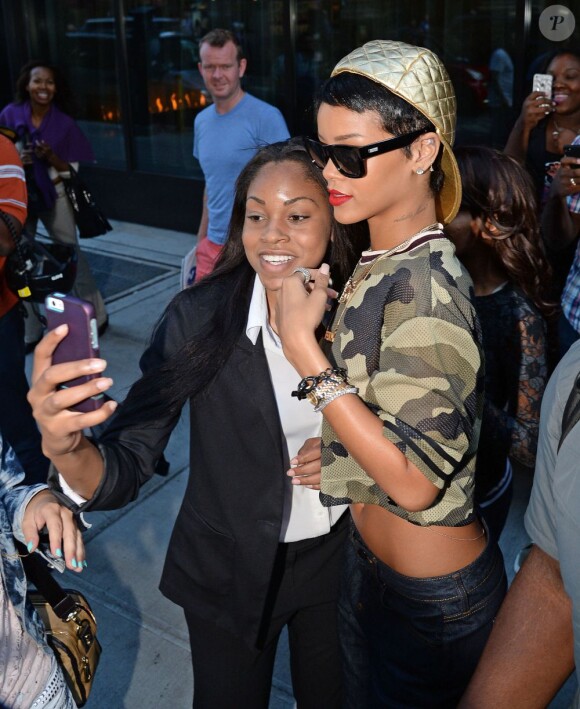 Rihanna et une fan à New York, le 14 aout 2013.