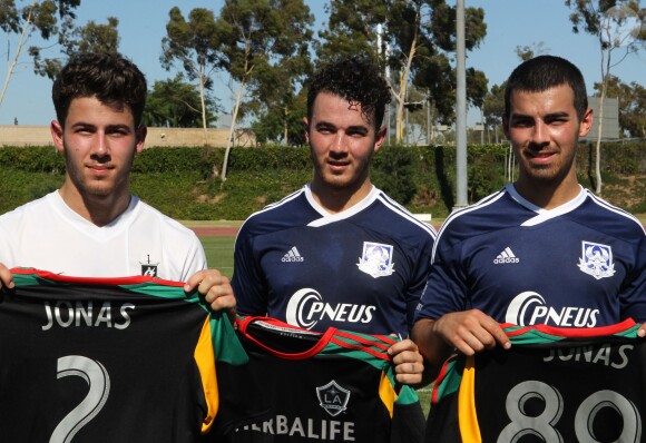 Kevin, Joe et Nick Jonas du groupe Jonas Brothers sur un terrain de foot de Los Angeles à l'occasion d'un match caritatif au profit de l'association Jonas Brothers Change for the Children Foundation, le 17 août 2013.