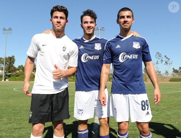 Kevin, Joe et Nick Jonas du groupe Jonas Brothers sur un terrain de foot de Los Angeles à l'occasion d'un match caritatif au profit de l'association Jonas Brothers Change for the Children Foundation, le 17 août 2013.