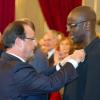 Le Président François Hollande épingle la légion d'honneur à Lilian Thuram le 17 septembre 2013 au Palais de l'Elysée.