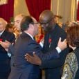 Le Président François Hollande épingle la légion d'honneur à Lilian Thuram le 17 septembre 2013 au Palais de l'Elysée.