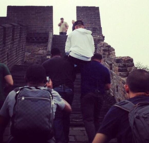 Justin Bieber se fait porter par ses gardes du corps pour aller visiter la Grande Muraille de Chine, le 30 septembre 2013.