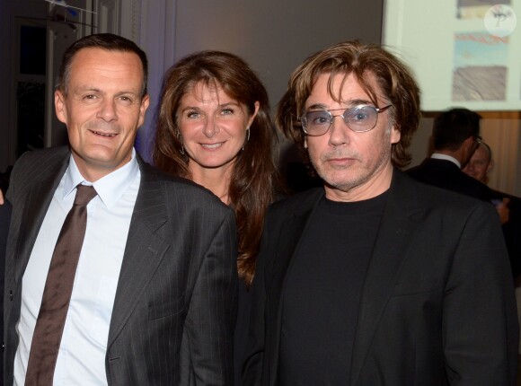 Emmanuel Bret (BMW) et Jean-Michel Jarre entourent Caroline Pois à la soirée des 80 ans d'Air France, à Paris, le 7 octobre 2013.