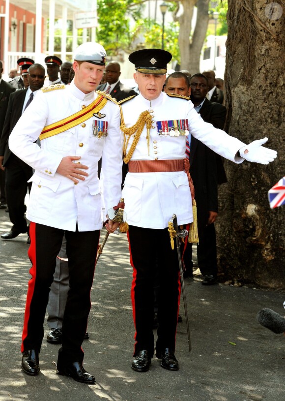 Le prince Harry avec son secrétaire particulier (et celui de William et Kate) Jamie Lowther-Pinkerton en mars 2012 à Nassau. Jamie Lowther-Pinkerton, fait en 2013 lieutenant dans l'ordre royal de Victoria, a été choisi pour parrain du prince George par le duc et la duchesse de Cambridge, pour son baptême le 23 octobre 2013.