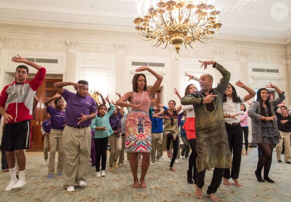 Michelle Obama participe avec d'autres élèves à un cours de danse facon Bollywood à l'occasion de la fête hindoue Diwali, dans le salle des réceptions de la Maison Blanche à Washington, le 5 Novembre 2013.