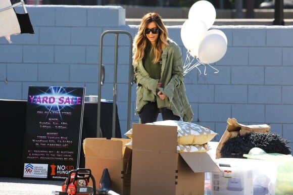 Kim Kardashian, radieuse lors du vide-grenier de sa famille dans le quartier de Woodland Hills, à Los Angeles. Les bénéfices de la vente seront reversés à deux associations caritatives. Los Angeles, le 10 novembre 2013.