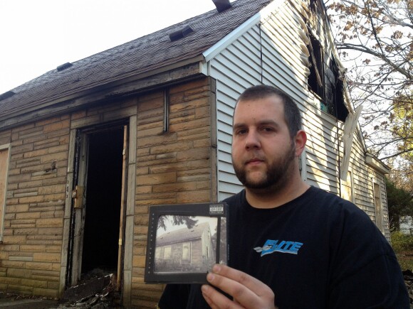 Mat Toporek, fan d'Eminem, pose devant la maison d'enfance incendiée de son idole avec son exemplaire de l'album The Marshall Mathers LP 2. Détroit, le 8 novembre 2013.