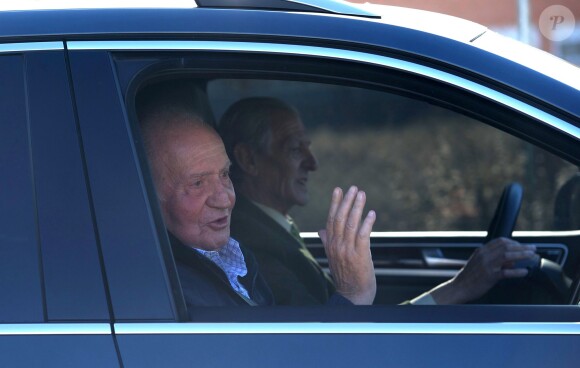 Le roi Juan Carlos Ier d'Espagne salue les médias en quittant l'hôpital Quiron, le 25 novembre 2013 à Madrid, quatre jours après avoir subi une nouvelle opération pour la pose d'une nouvelle prothèse à la hanche gauche.