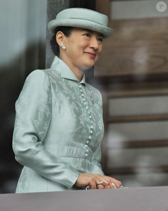 La princesse héritière Masako salue depuis un balcon du palais la foule venue nombreuse pour célébrer le 80e anniversaire de l'empereur, à Tokyo le 23 décembre 2013.